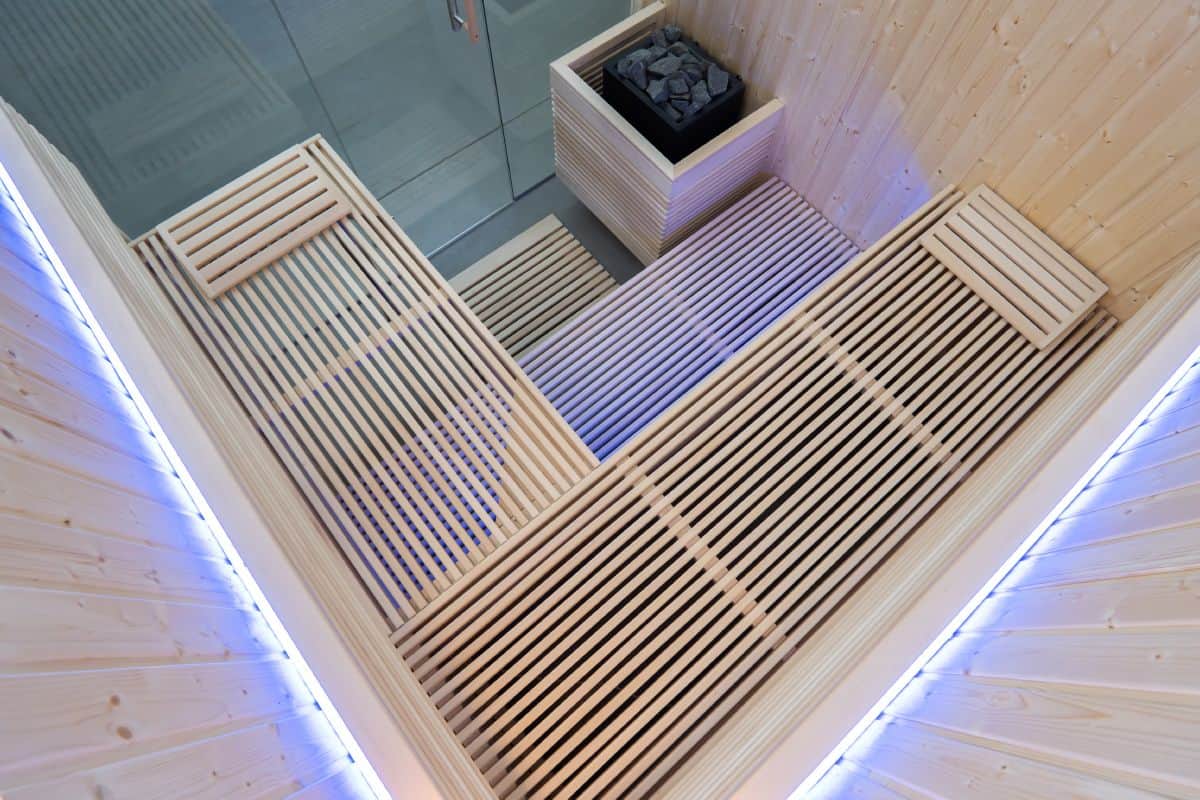 Sentiotec_Panorama Large_PANORAMA-L_d1 Zone wellness con sedili in legno e sauna a infrarossi, ambientazione interna moderna e rilassante.