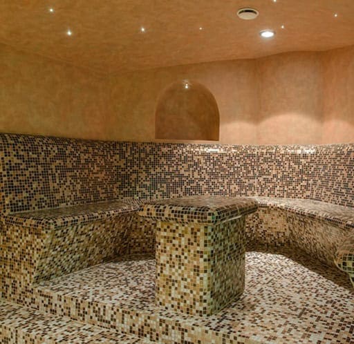 Bagnoturco_1 Piscina coperta con rivestimento in mosaico, spazio rilassante con area lounge adatta al wellness.