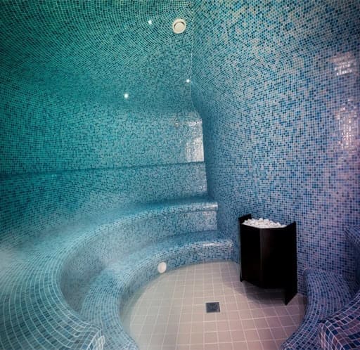 Bagnoturco_4 L'immagine mostra una piscina coperta interrata con rivestimento a mosaico blu.