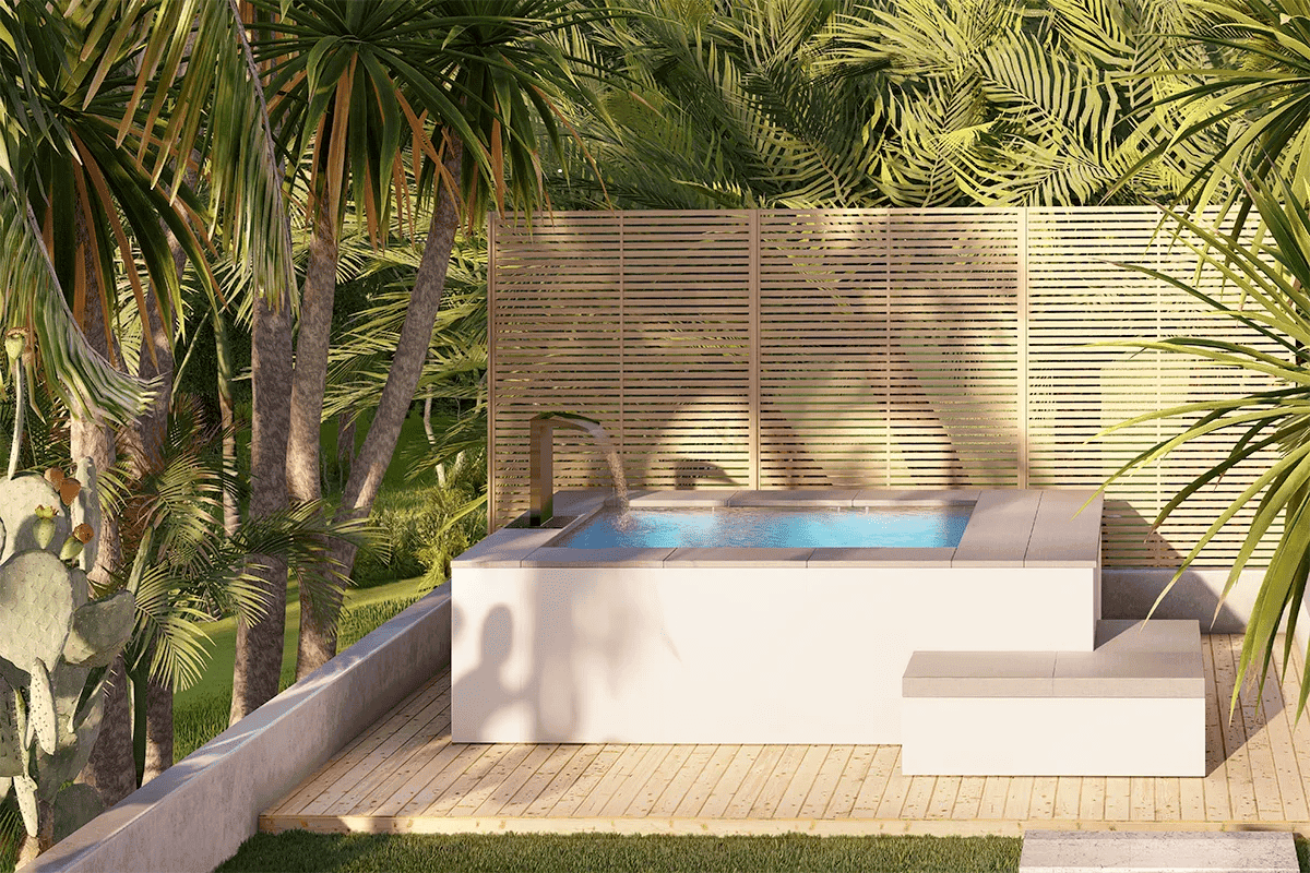 Recta-02 L'immagine mostra una piscina idromassaggio interrata con struttura moderna, circondata da piante tropicali e una recinzione in legno per privacy.