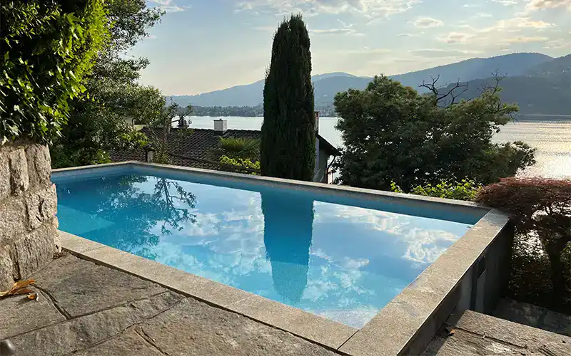 Piscina ristrutturata a Carabietta con rivestimento in PVC Touch, bordo in sasso e scala romana