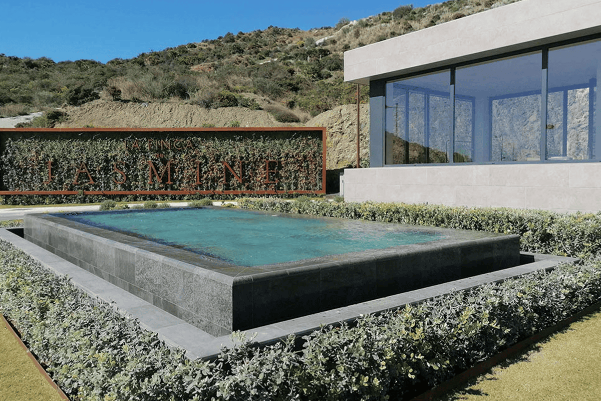 Piscina moderna rivestita in gres porcellanato Piscina rivestita in gres porcellanato grigio con bordo a sfioro elegante.