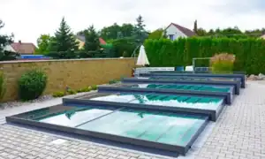 Copertura telescopica_bassa Copertura telescopica per piscina in alluminio e policarbonato, con moduli scorrevoli trasparenti