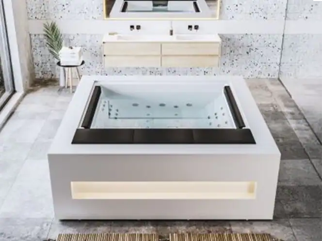 PURE-Vasca idromassaggio design moderno con illuminazione LED integrata Vasca idromassaggio quadrata con rivestimento bianco, cuscini neri e illuminazione LED, in bagno elegante e luminoso