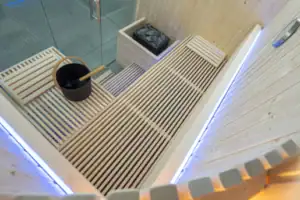 Panorama_Small-03 Relaxing outdoor wellness area with a wooden sauna and hot stone, perfect for relaxing after a swim or sauna session in a private setting.