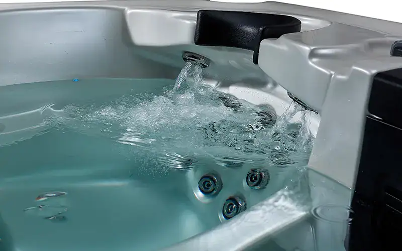 Piscina idromassaggio con getti d'acqua, superficie bianca, ambiente interno. Piscina idromassaggio con getti d'acqua, superficie bianca, ambiente interno.